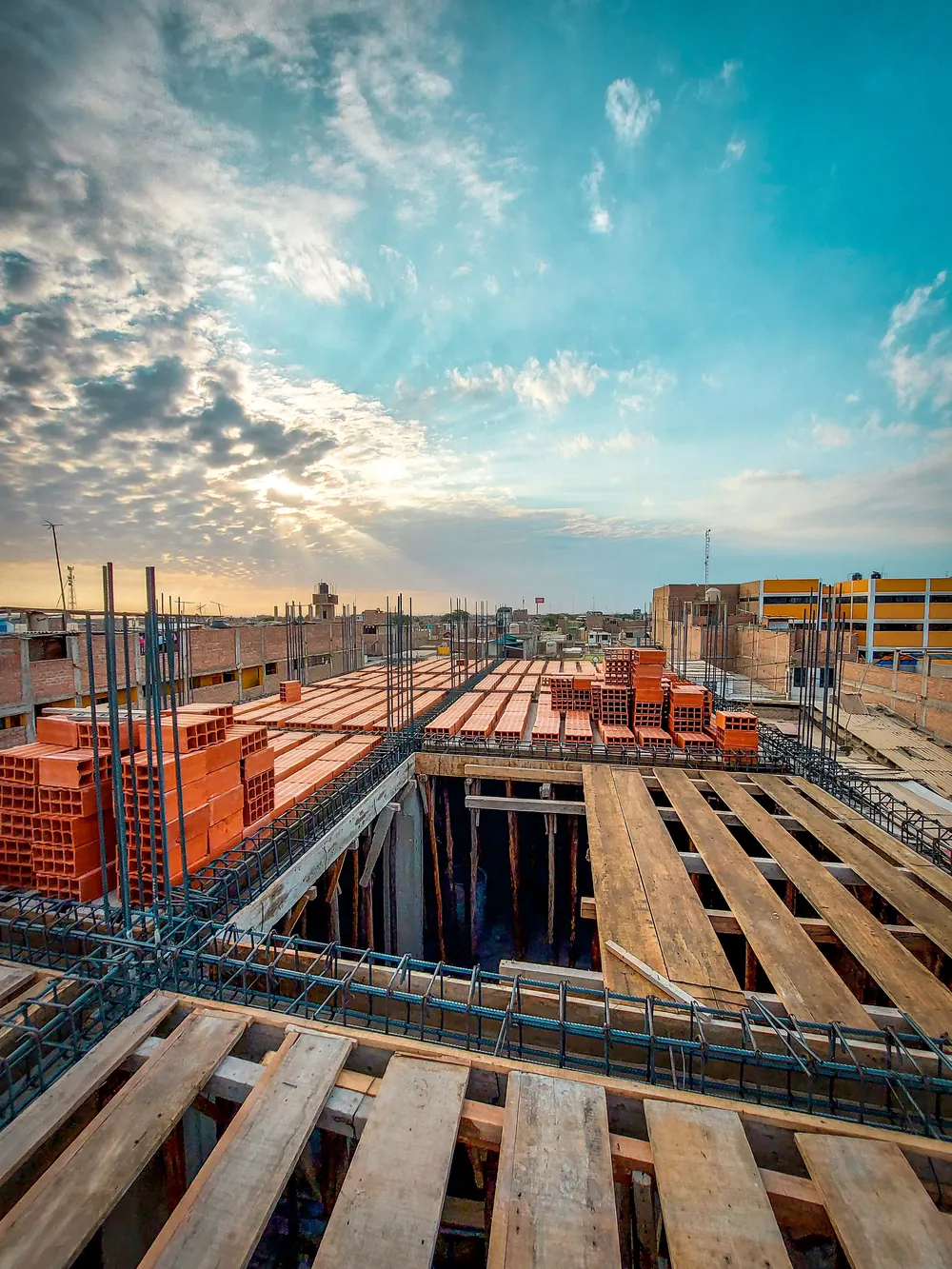 Losa en construcción al amanecer, con el encofrado de madera armado, los hierros atados y los ladrillos huecos ya distribuidos
