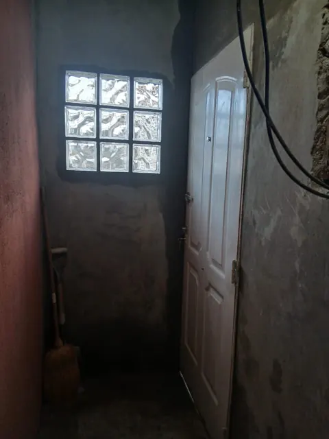 Interior con ventana de ladrillo de vidrio y puerta