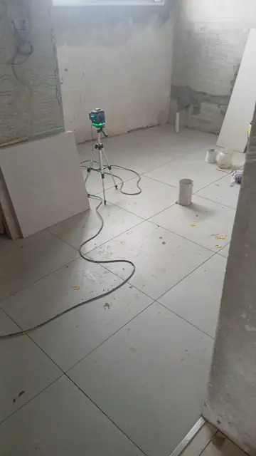 Nivel láser marcando piso y revestimiento
